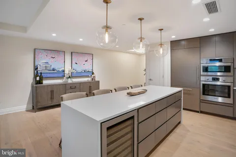 a kitchen with kitchen island a sink stainless steel appliances and cabinets