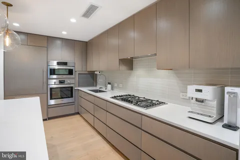a kitchen with stainless steel appliances kitchen island granite countertop a stove and a refrigerator
