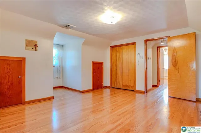 a view of empty room with wooden floor