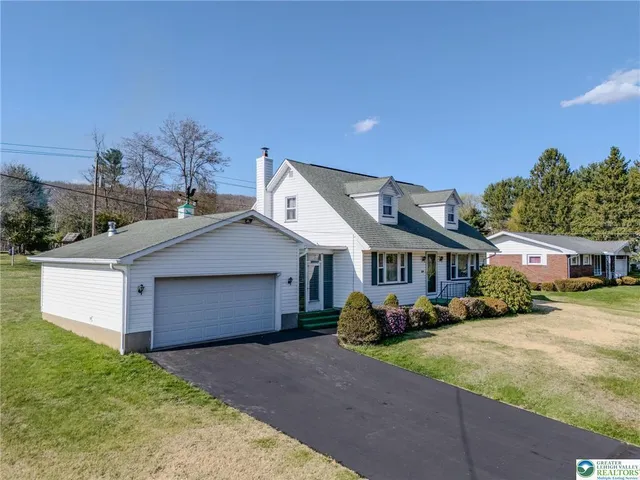 a front view of a house with a garden and plants