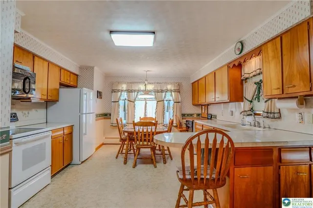 a kitchen with stainless steel appliances granite countertop table chairs sink and cabinets