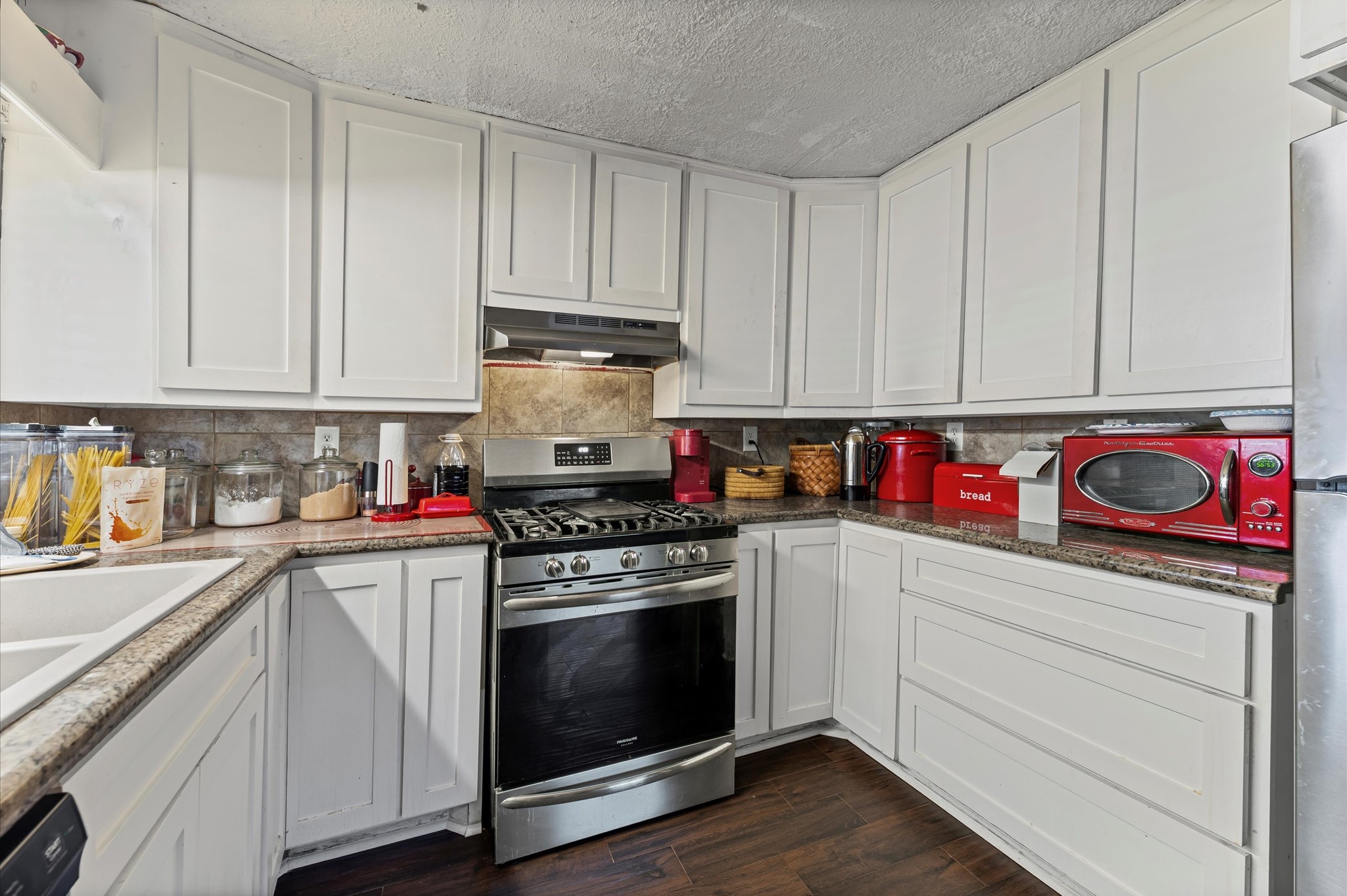 16032 1/2 Ridlon Street Channelview, TX 77530 - Photo 8 of 44 a kitchen with stainless steel appliances granite countertop a stove and cabinets