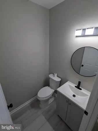 a bathroom with a granite countertop toilet and a sink