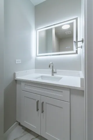 a bathroom with a sink vanity and mirror