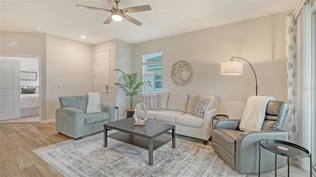 a living room with furniture a clock and wooden floor
