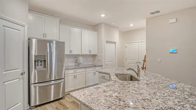a kitchen with stainless steel appliances granite countertop a refrigerator sink and stove