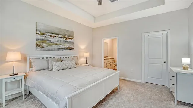 a spacious bedroom with a bed and a lamp