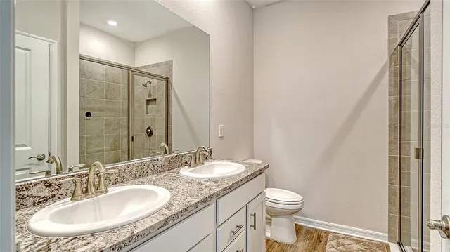 a bathroom with a granite countertop sink a toilet and a mirror