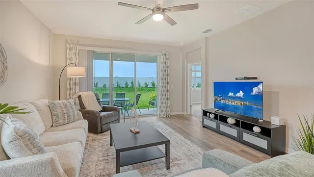 a living room with furniture a large window and a flat screen tv