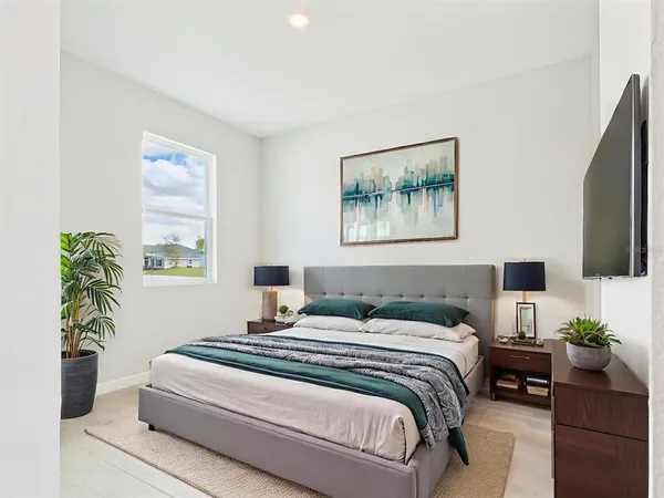 a bedroom with a bed and a potted plant