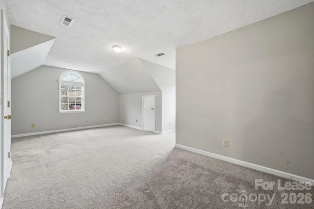 an empty room with a windows and a ceiling fan