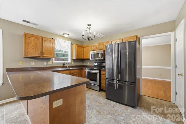 a kitchen with granite countertop stainless steel appliances a refrigerator microwave and sink