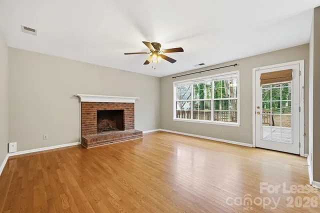 a view of an empty room with a fireplace and a window