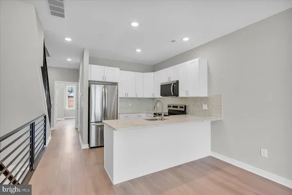a kitchen with stainless steel appliances a refrigerator sink and microwave