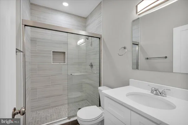 a bathroom with a sink a toilet and shower
