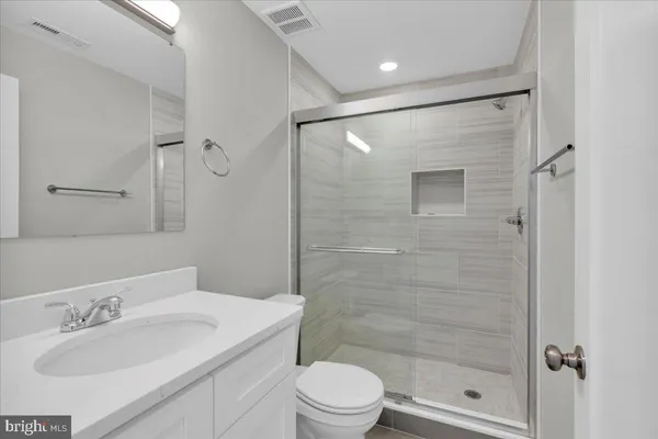 a bathroom with a sink a toilet and shower