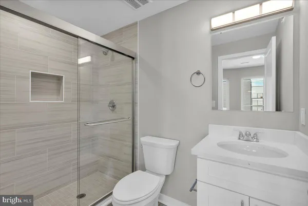 a bathroom with a toilet sink vanity and shower