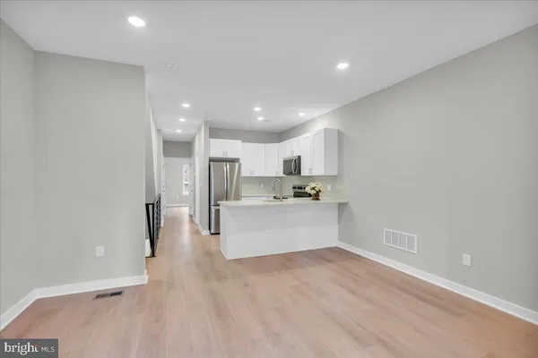 a view of kitchen with kitchen island white cabinets and refrigerator