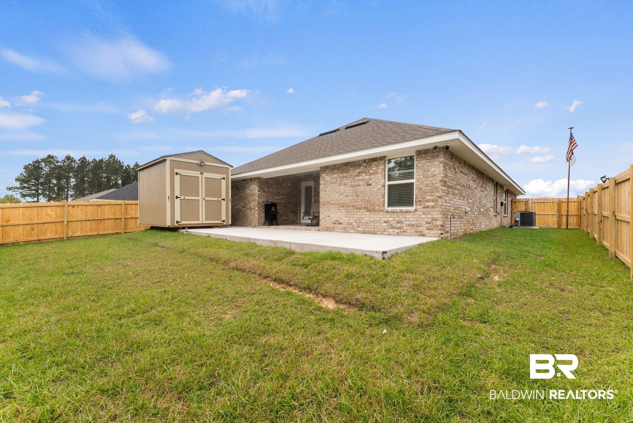 692 Mayflower Drive Foley, AL 36535 - Photo 37 of 40 Rear view of property featuring a storage shed, brick siding, a fenced backyard, a patio, and roof with shingles