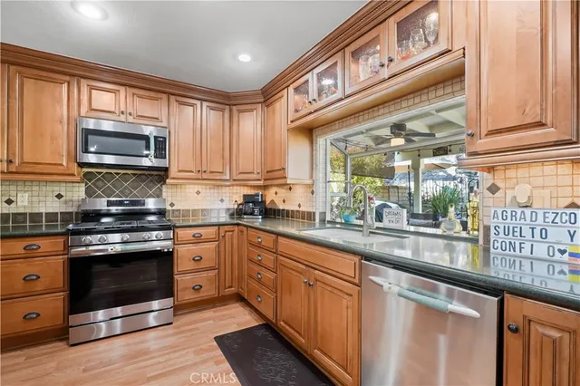 a kitchen with stainless steel appliances granite countertop a stove microwave and cabinets