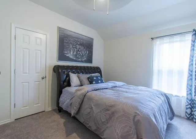 a bed sitting in a bedroom next to a window