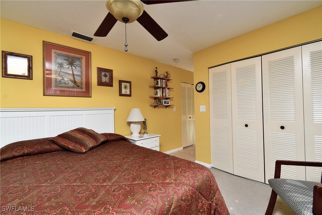 8 Park Ln Circle Lehigh Acres, FL 33936 - Photo 13 of 47 a bedroom with a bed and a chandelier