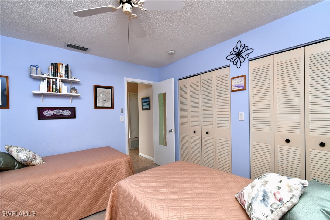 8 Park Ln Circle Lehigh Acres, FL 33936 - Photo 16 of 47 a bedroom with a bed and a chandelier