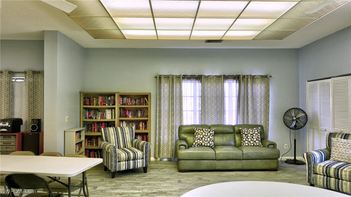 8 Park Ln Circle Lehigh Acres, FL 33936 - Photo 34 of 47 a living room with furniture a rug and a book shelf