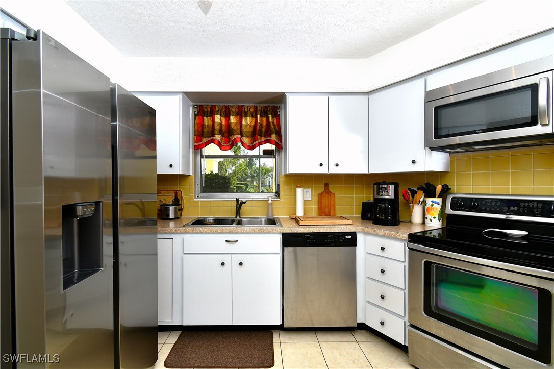 8 Park Ln Circle Lehigh Acres, FL 33936 - Photo 4 of 47 a kitchen with stainless steel appliances a stove microwave and cabinets