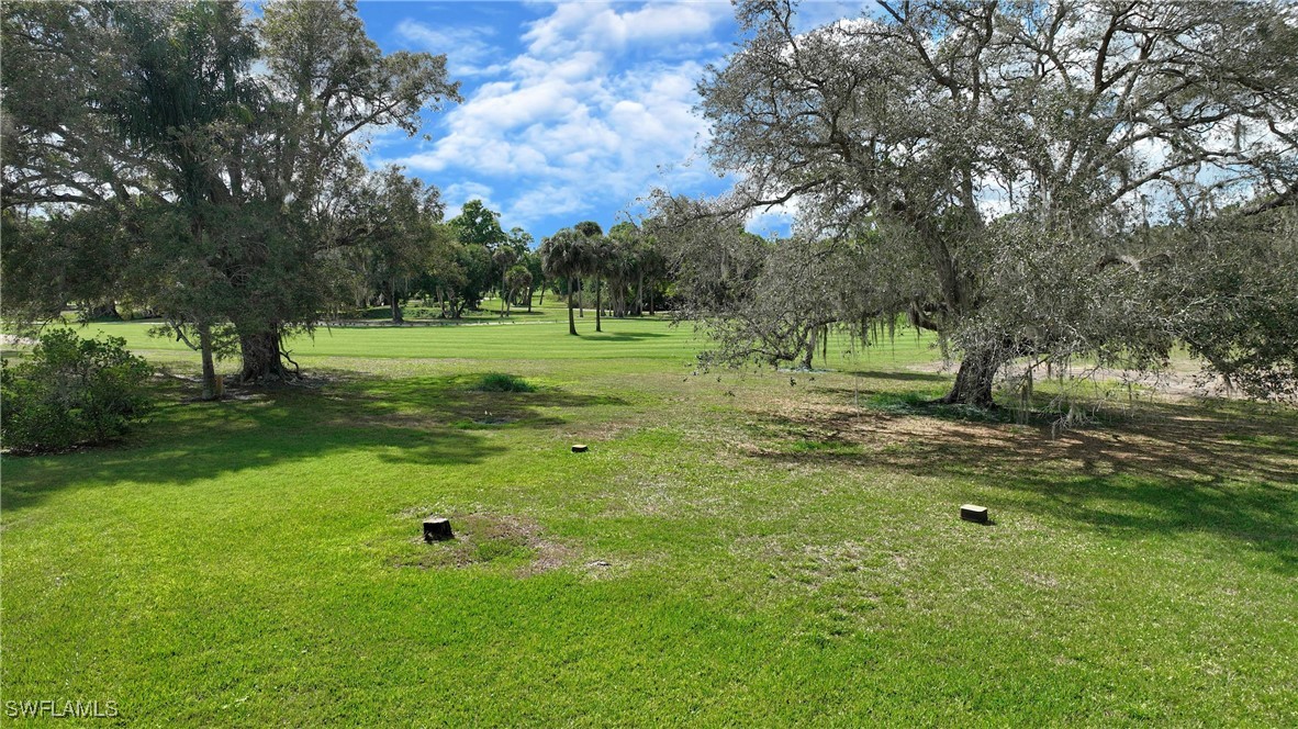 8 Park Ln Circle Lehigh Acres, FL 33936 - Photo 45 of 47 a view of outdoor space with green field and trees all around