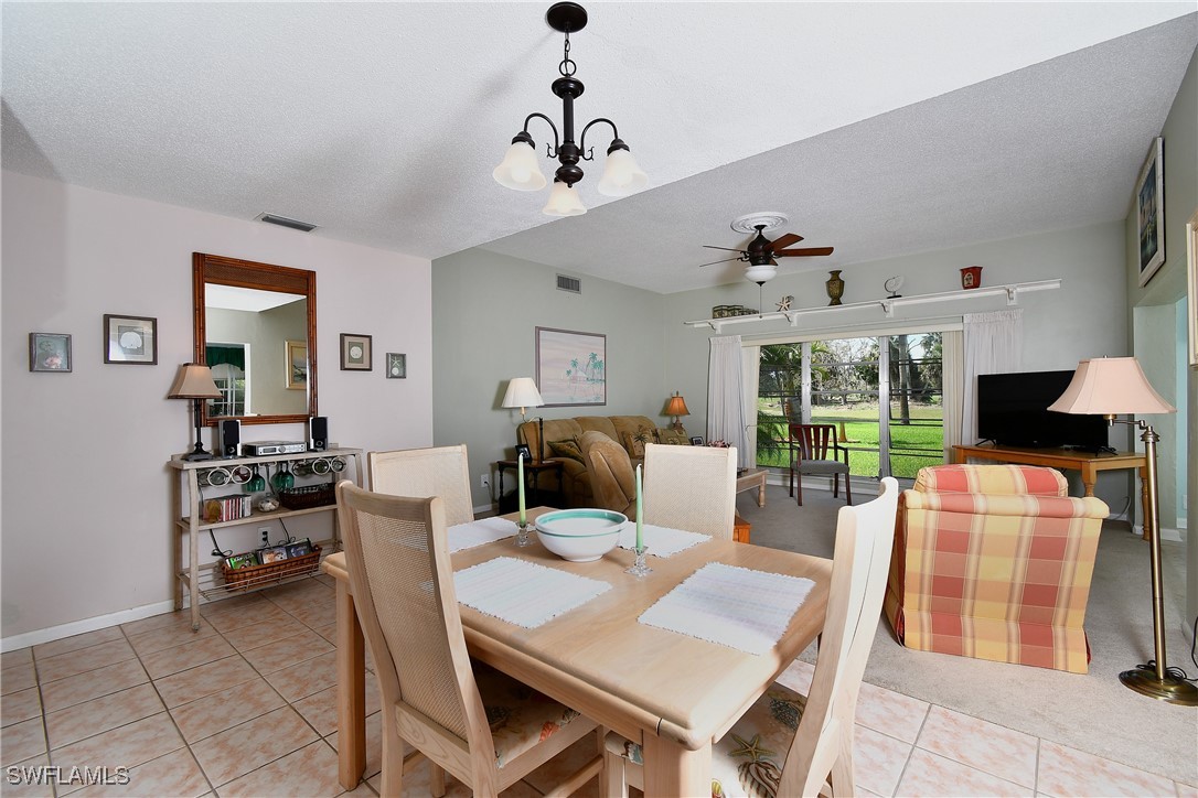 8 Park Ln Circle Lehigh Acres, FL 33936 - Photo 8 of 47 a living room with furniture a chandelier and a dining table