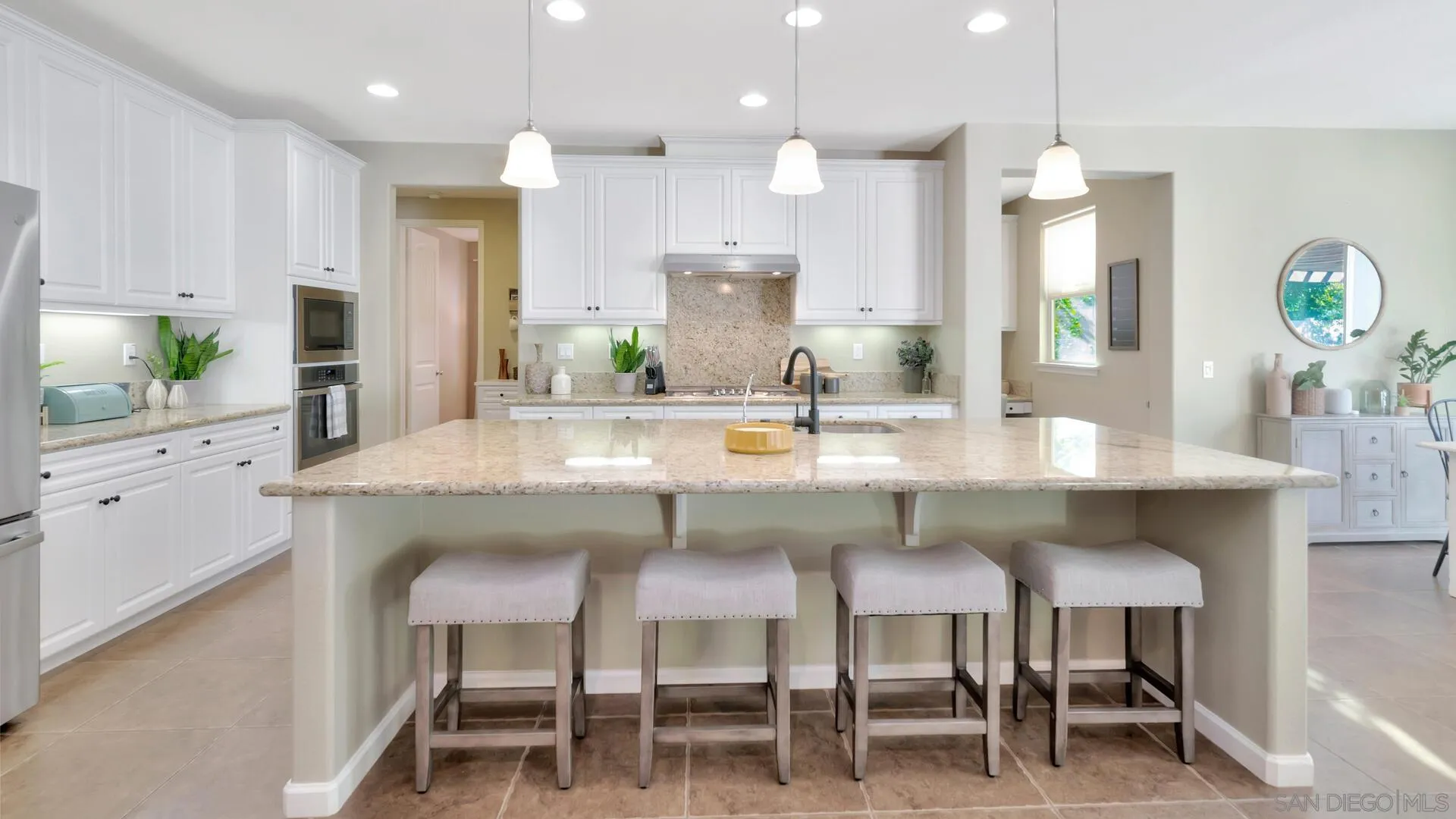 17568 Ralphs Ranch Road San Diego, CA 92127 - Photo 6 of 59 a kitchen with kitchen island granite countertop a table and chairs in it