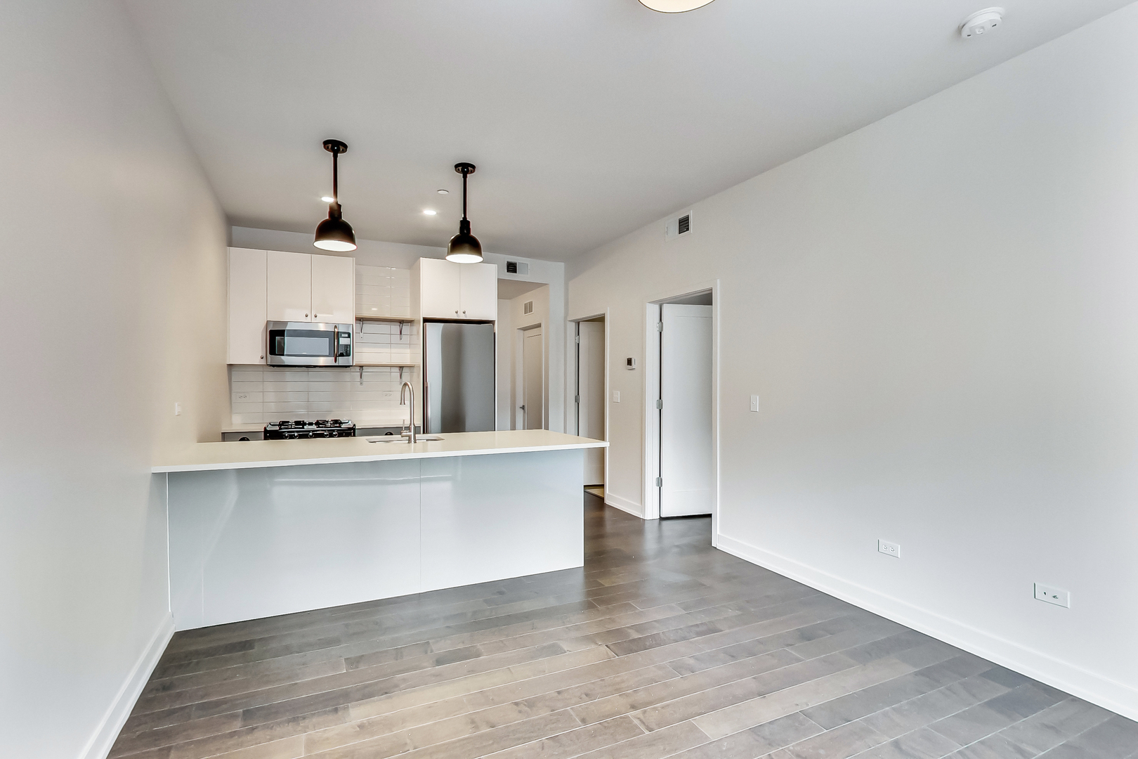 Undisclosed Address Chicago, IL 60613 - Photo 8 of 13 a kitchen with kitchen island white cabinets and stainless steel appliances