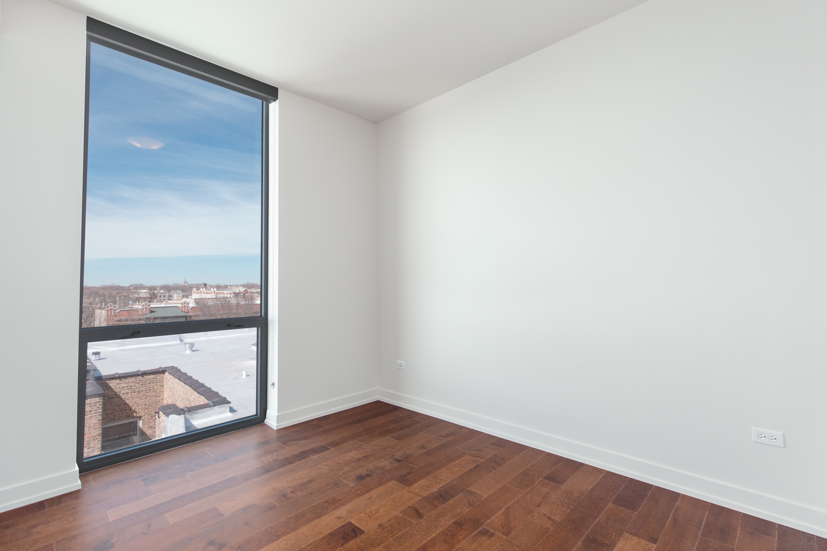 Undisclosed Address Chicago, IL 60613 - Photo 9 of 13 a view of an empty room with wooden floor and a window