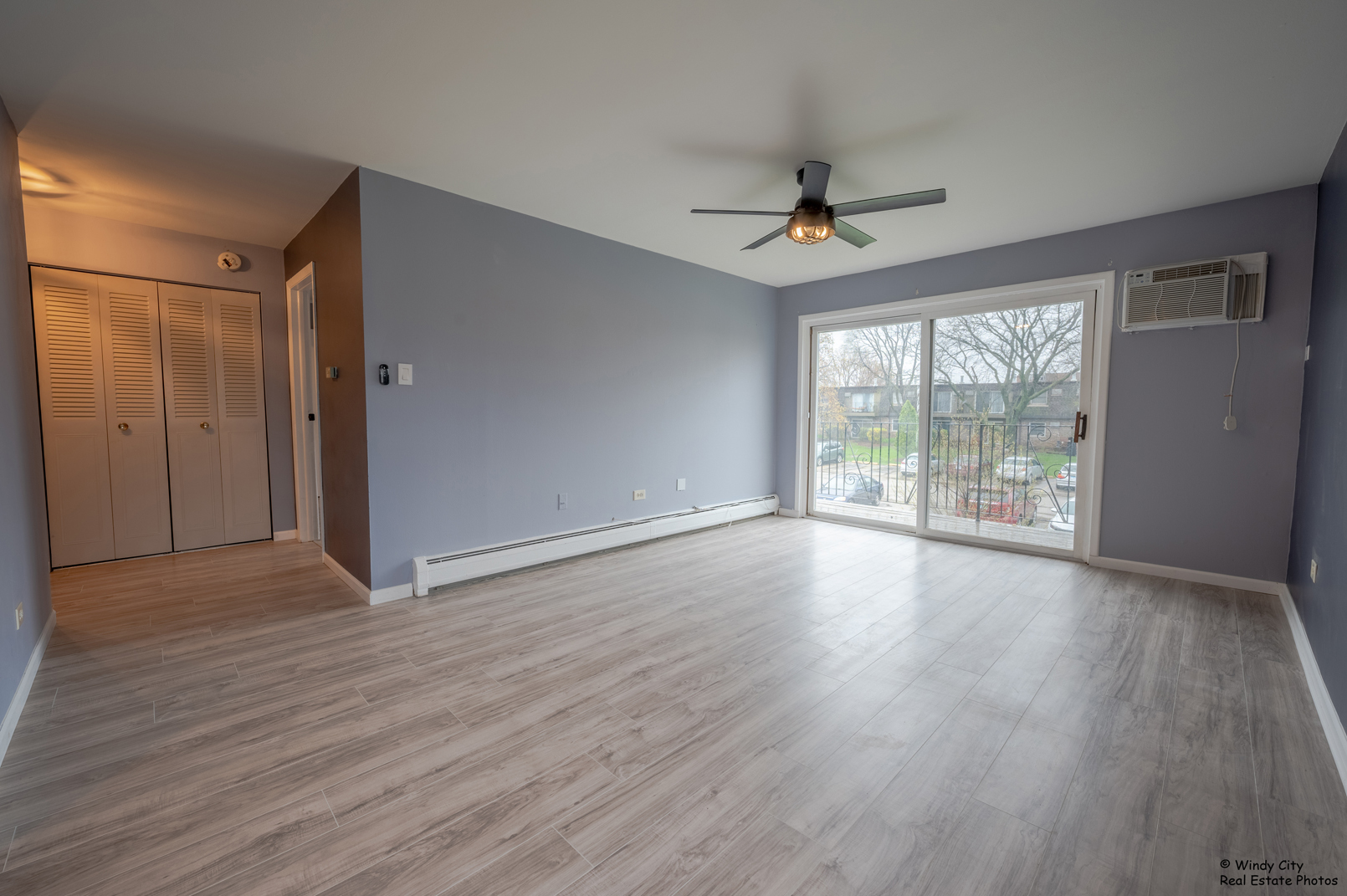 879 Trace Drive, Unit 202 Buffalo Grove, IL 60089 - Photo 4 of 15 an empty room with wooden floor chandelier and windows