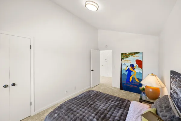 a bedroom with a bed and painting on the wall