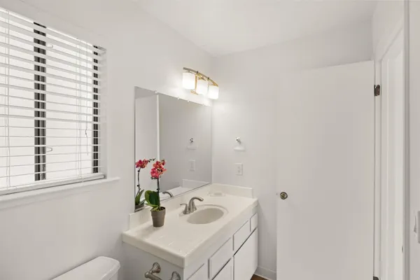a bathroom with a sink mirror and vanity