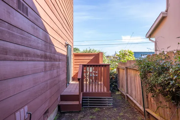 a balcony with wooden floor table and chairs