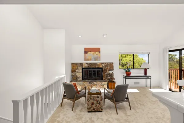 a living room with furniture a fireplace and a large window