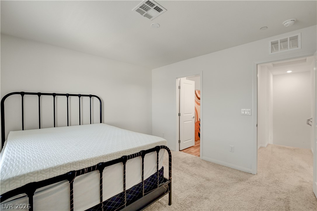 6924 Spicy Merlot Street North Las Vegas, NV 89086 - Photo 30 of 83 A spacious sleeping area awaits with plush carpeting and a doorway leading to an adjoining space.