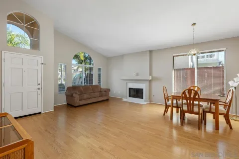 a view of livingroom with furniture wooden floor chandelier and windows