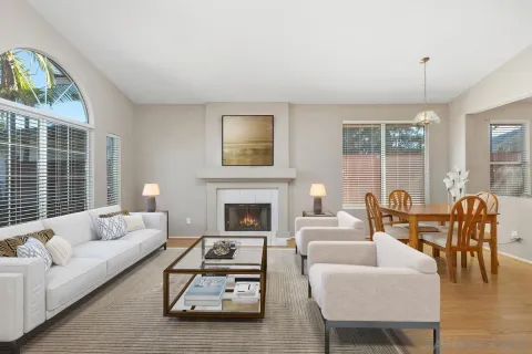 a living room with furniture fireplace and a large window