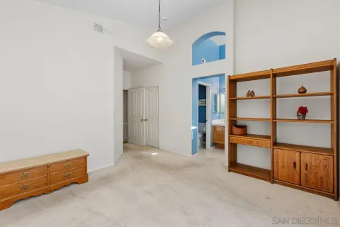 a view of an empty room with cabinet and a window