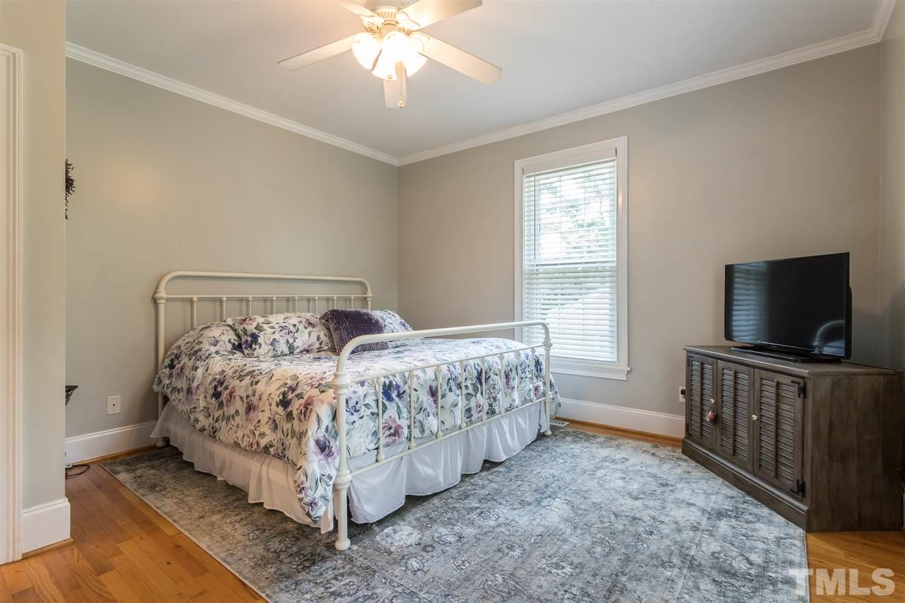 1208 Watauga Street Raleigh, NC 27604 - Photo 12 of 26 a bed room with a bed and a flat tv screen on a dresser