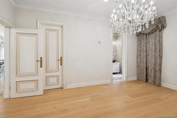 a view of an empty room with chandelier