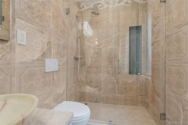 a bathroom with a granite countertop toilet a sink a shower and a mirror