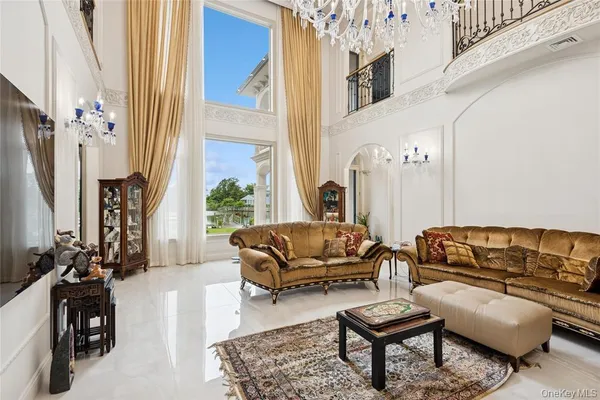 a living room with furniture a chandelier and a potted plant