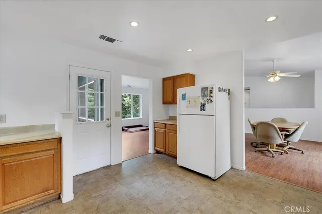 a view of a kitchen with fridge and workspace
