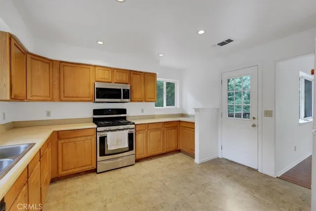 a kitchen with stainless steel appliances granite countertop a stove a sink and a refrigerator