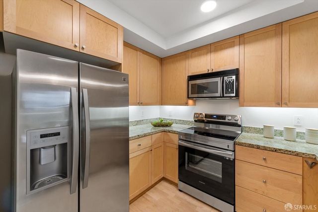 a kitchen with granite countertop cabinets sink and stove